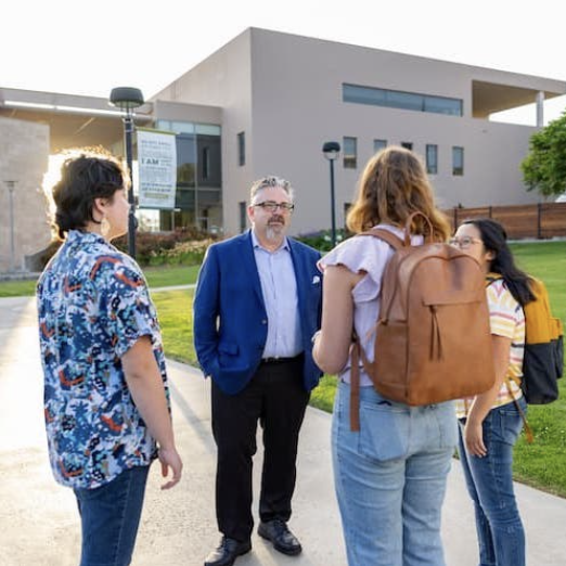 President Thomas speaking with students on campus